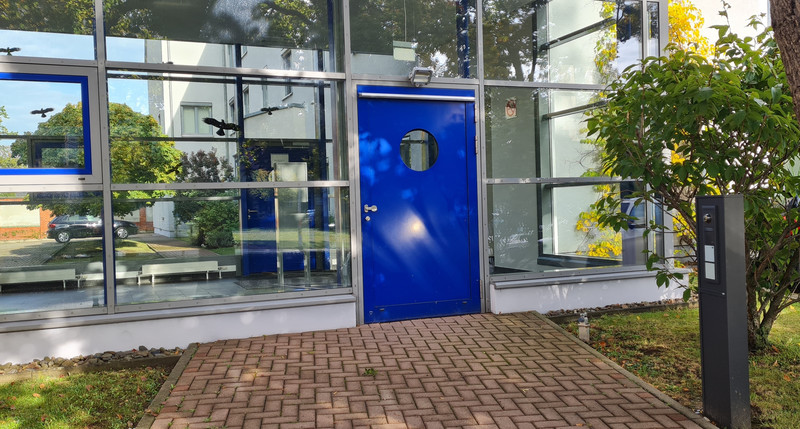 Nebeneingang mit Klingel Nebeneingang des Amtsgerichts mit Zugang zum barrierefreien Neubau und seitlicher Klingel rechts auf einer Stehle